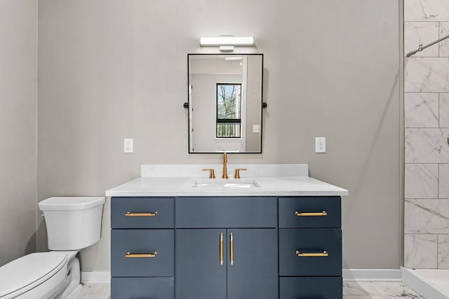 bathroom with tiled shower, vanity, and toilet