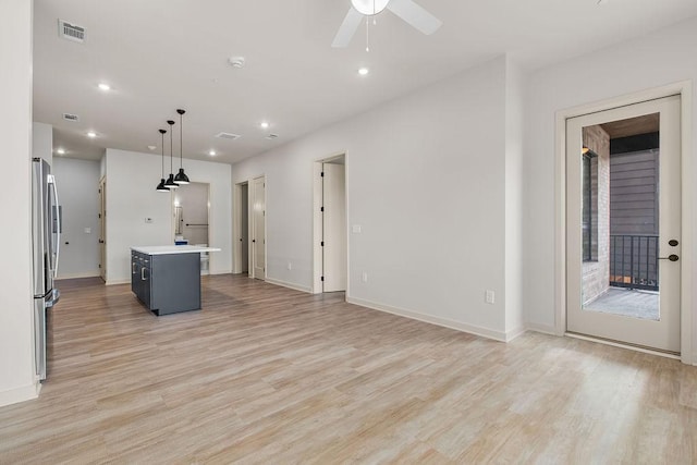 unfurnished living room featuring ceiling fan and light hardwood / wood-style floors