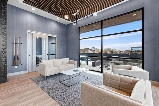 living room featuring a high ceiling, light hardwood / wood-style floors, and wood ceiling