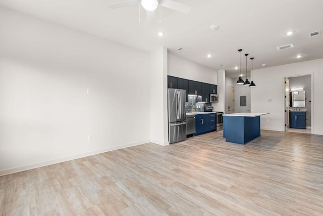 kitchen with ceiling fan, light wood-type flooring, appliances with stainless steel finishes, decorative light fixtures, and a kitchen island