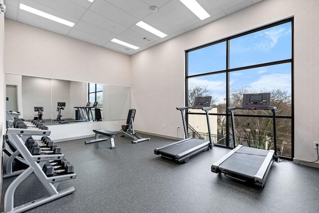 gym featuring a drop ceiling and a wealth of natural light