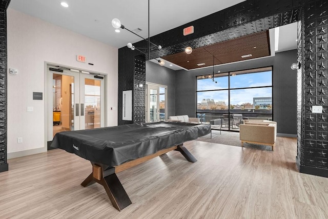 playroom with hardwood / wood-style floors, a towering ceiling, french doors, and billiards