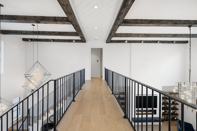 hallway featuring beamed ceiling, light hardwood / wood-style floors, and a notable chandelier