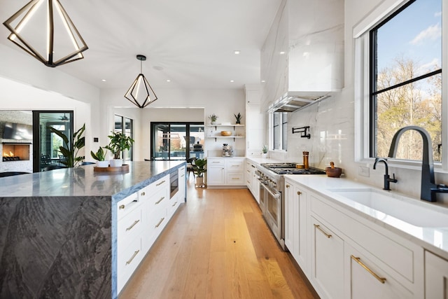 kitchen featuring dark stone countertops, plenty of natural light, extractor fan, and appliances with stainless steel finishes