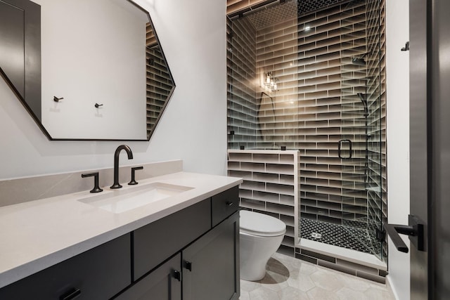 bathroom with tile patterned flooring, vanity, toilet, and a tile shower