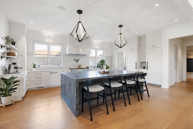 kitchen featuring white cabinetry, a center island, plenty of natural light, and light hardwood / wood-style flooring