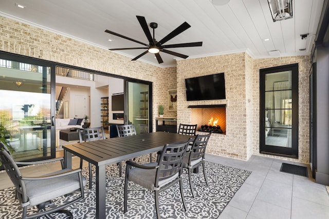 view of patio with ceiling fan and a large fireplace