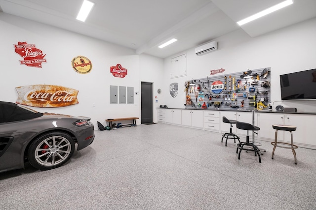 garage featuring a workshop area and a wall mounted AC