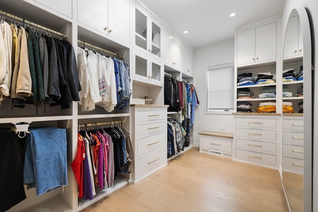 walk in closet with light hardwood / wood-style flooring