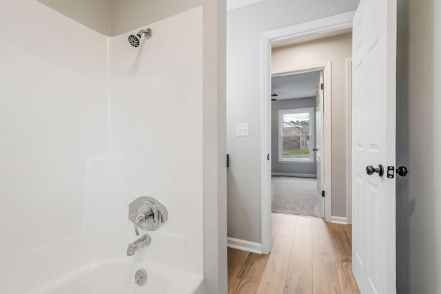 bathroom featuring bathing tub / shower combination and hardwood / wood-style flooring