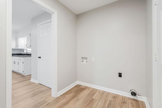 laundry room featuring hookup for an electric dryer, sink, hookup for a washing machine, and light hardwood / wood-style flooring