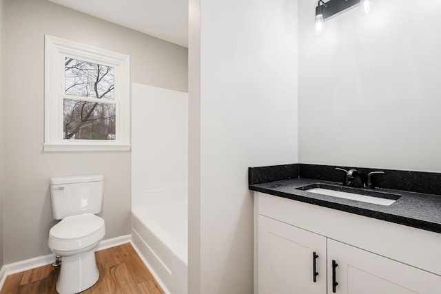 bathroom with hardwood / wood-style floors, vanity, and toilet