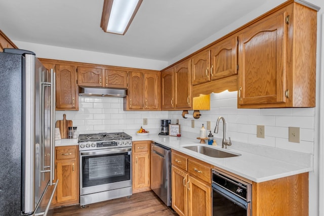 kitchen featuring dark hardwood / wood-style floors, decorative backsplash, sink, and appliances with stainless steel finishes