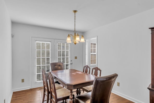 dining space with an inviting chandelier and hardwood / wood-style flooring