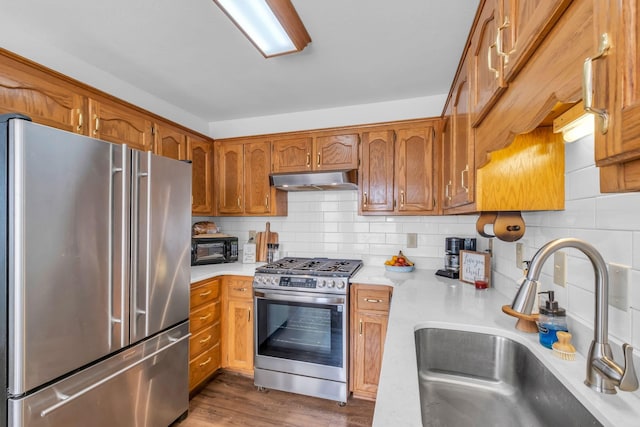 kitchen featuring decorative backsplash, stainless steel appliances, dark hardwood / wood-style floors, and sink