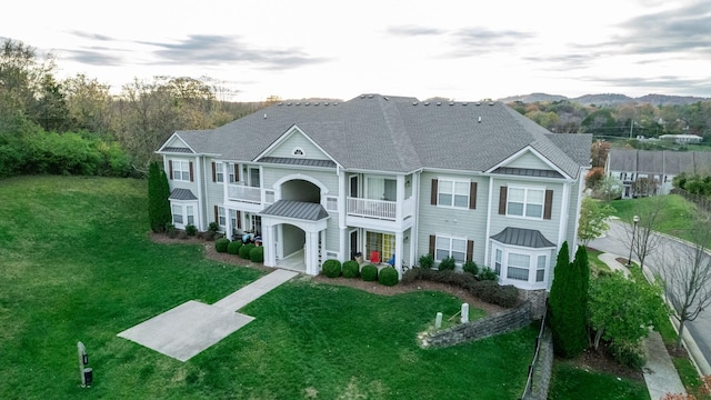 view of front of home featuring a balcony and a front lawn