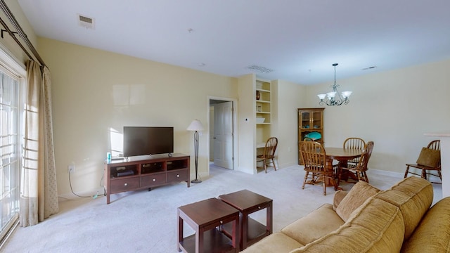 carpeted living room with a notable chandelier and a healthy amount of sunlight