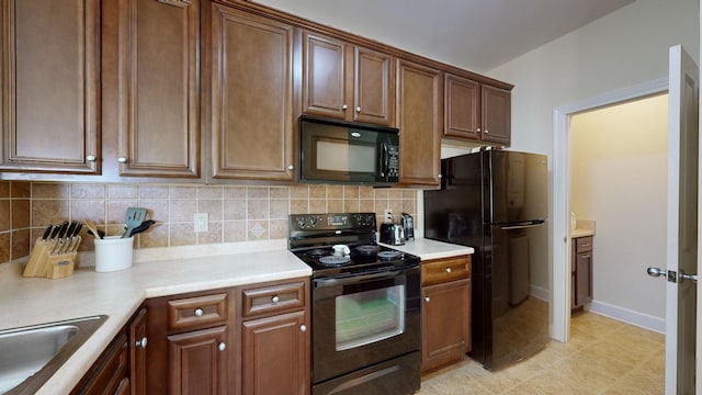 kitchen featuring black appliances, sink, and tasteful backsplash