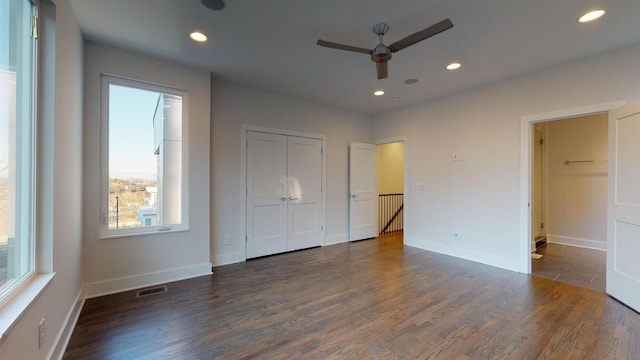 unfurnished bedroom with ceiling fan and dark wood-type flooring