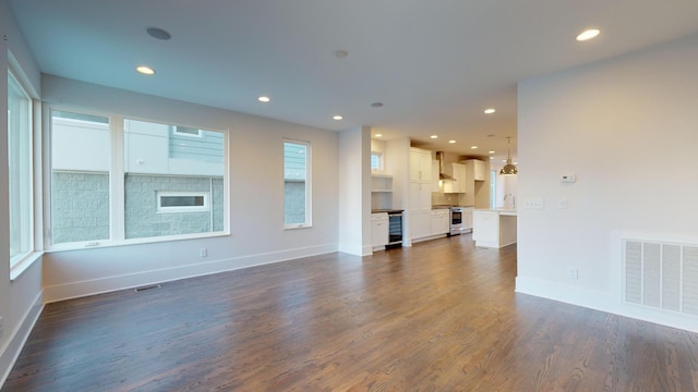 unfurnished living room with dark hardwood / wood-style flooring, beverage cooler, and sink