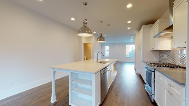 kitchen with stainless steel appliances, sink, decorative light fixtures, dark hardwood / wood-style floors, and an island with sink