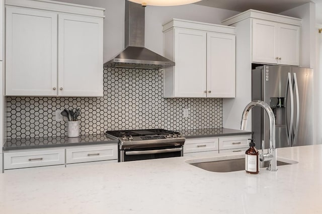 kitchen featuring white cabinets, wall chimney range hood, and stainless steel appliances