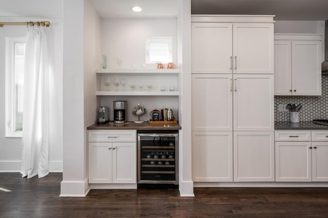 bar featuring tasteful backsplash, white cabinetry, beverage cooler, and dark wood-type flooring