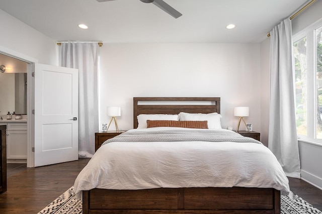 bedroom with dark hardwood / wood-style floors, ensuite bathroom, multiple windows, and ceiling fan