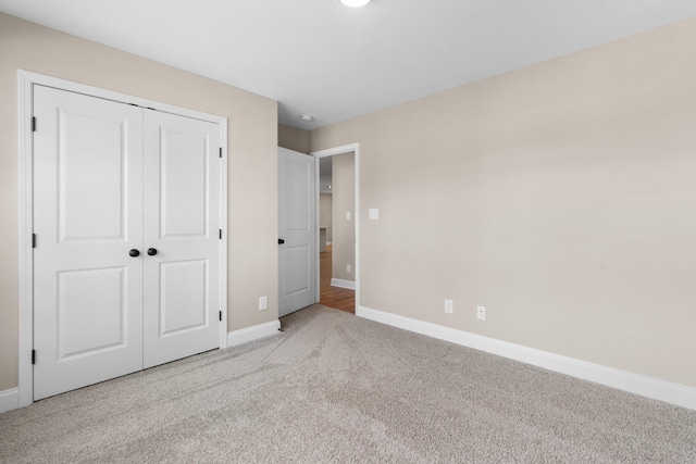 unfurnished bedroom featuring light carpet and a closet