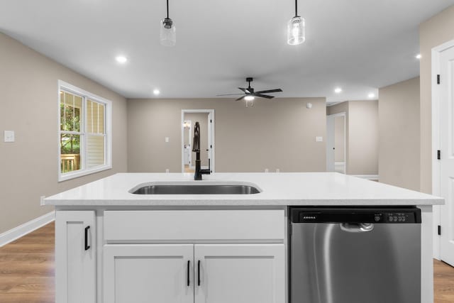 kitchen with dishwasher, sink, light wood-type flooring, decorative light fixtures, and white cabinetry