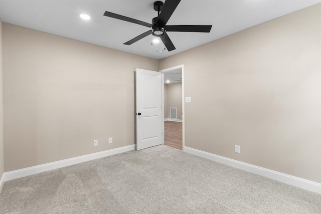 carpeted spare room with ceiling fan