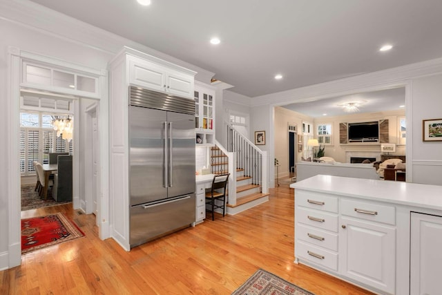 kitchen featuring built in fridge, crown molding, white cabinets, and light hardwood / wood-style floors