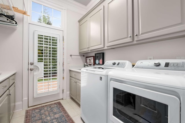 laundry room with ornamental molding, light tile patterned floors, cabinets, and independent washer and dryer