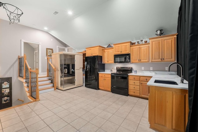 kitchen featuring light tile patterned flooring, sink, vaulted ceiling, and black appliances