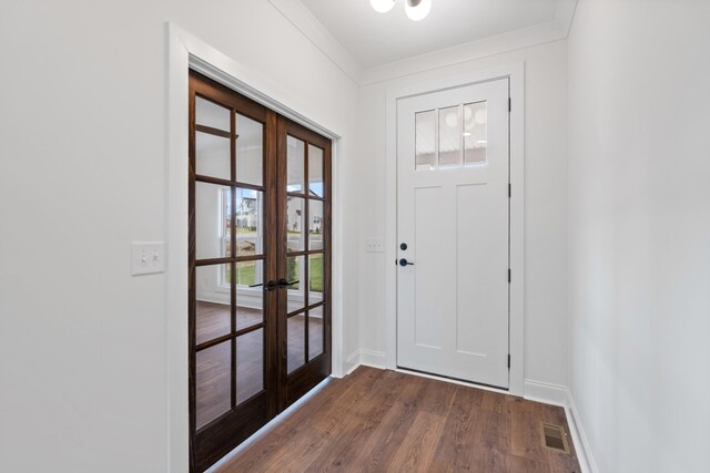 entrance foyer featuring plenty of natural light, dark wood-type flooring, french doors, and ornamental molding