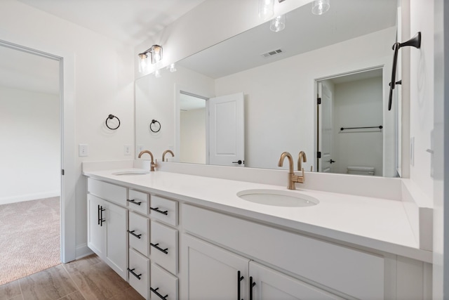 bathroom featuring vanity, wood-type flooring, and toilet