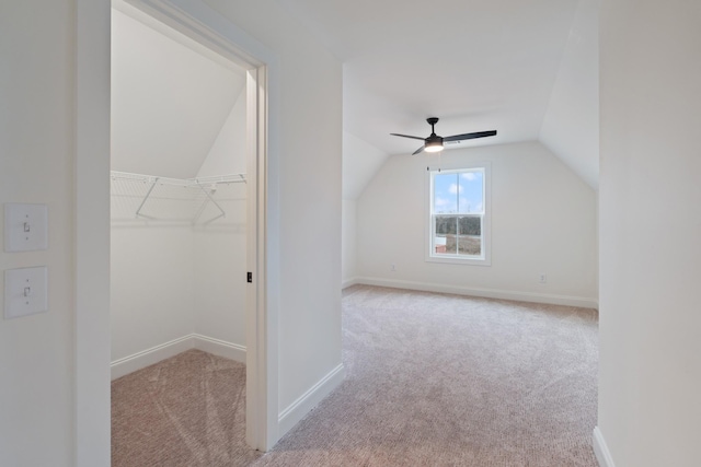 additional living space featuring ceiling fan, light colored carpet, and vaulted ceiling