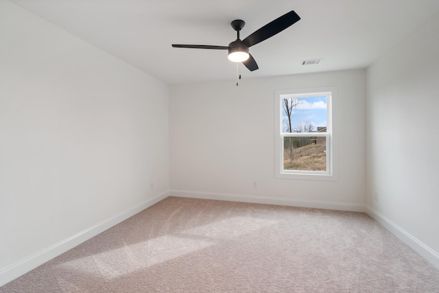 carpeted spare room featuring ceiling fan