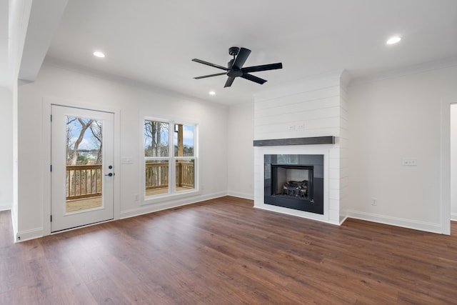 unfurnished living room featuring dark hardwood / wood-style floors, ceiling fan, ornamental molding, and a fireplace