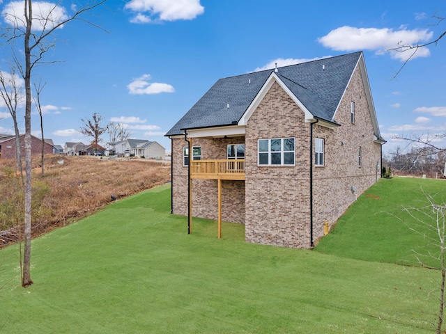 back of property featuring a balcony and a yard