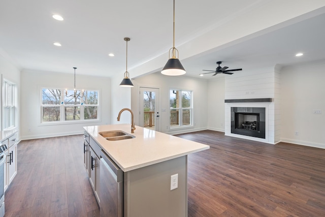 kitchen featuring a center island with sink, hanging light fixtures, a healthy amount of sunlight, and sink