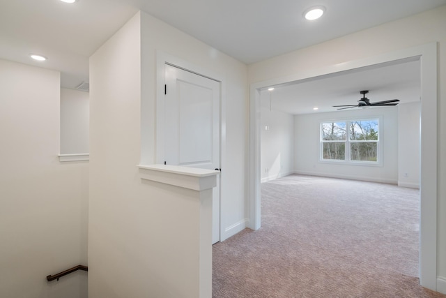 hallway featuring light colored carpet