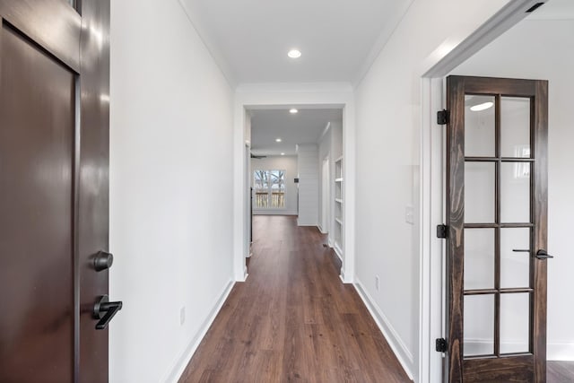 corridor with ornamental molding and dark wood-type flooring