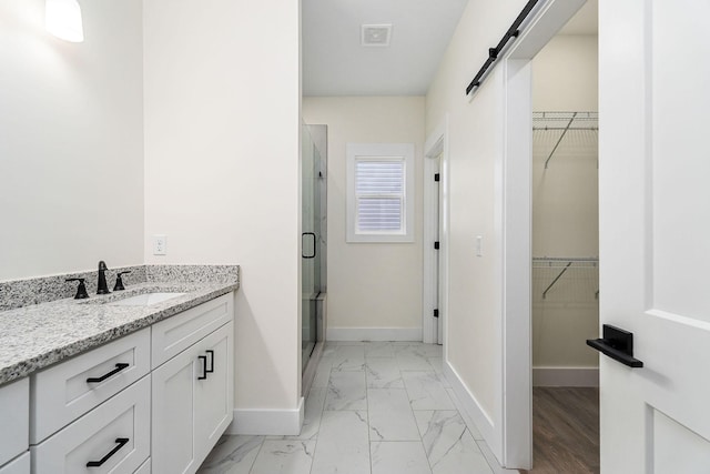 bathroom with vanity and a shower with door