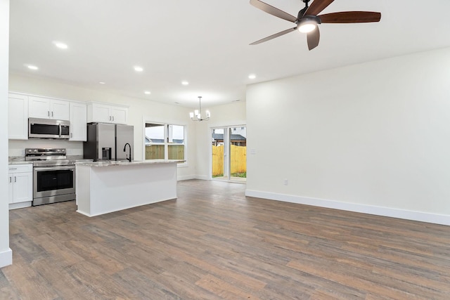 kitchen with an island with sink, wood-type flooring, decorative light fixtures, white cabinets, and appliances with stainless steel finishes