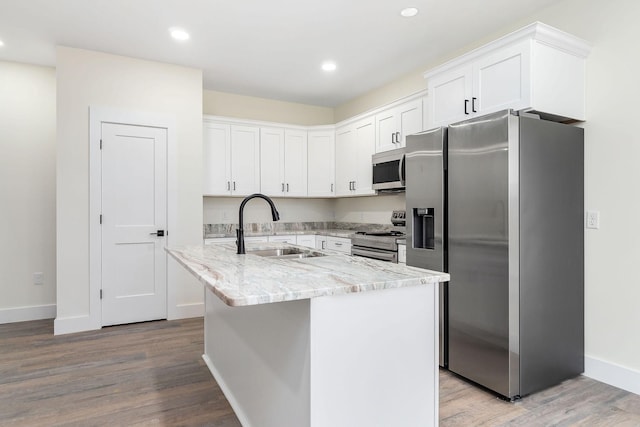 kitchen featuring a center island with sink, light hardwood / wood-style floors, white cabinetry, and stainless steel appliances