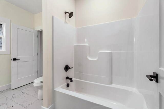 bathroom featuring shower / bathing tub combination and toilet