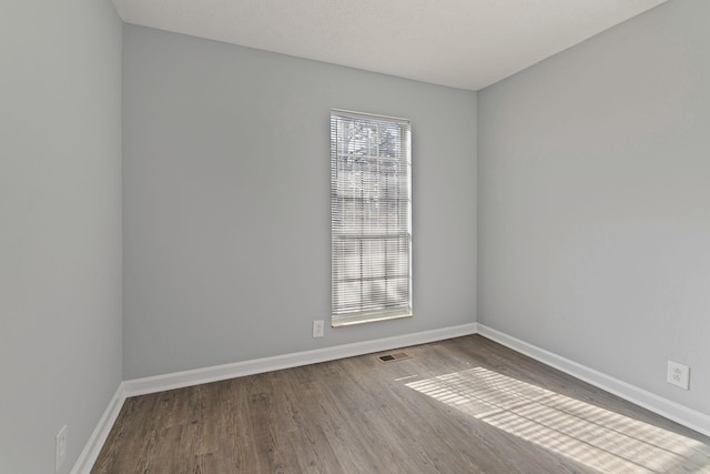 unfurnished room with hardwood / wood-style flooring