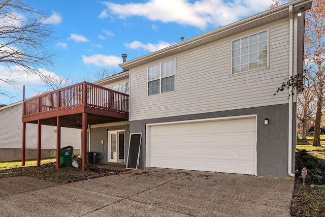 rear view of property featuring central AC, a garage, and a deck