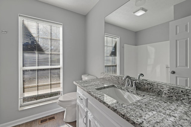 bathroom with walk in shower, wood-type flooring, a textured ceiling, toilet, and vanity